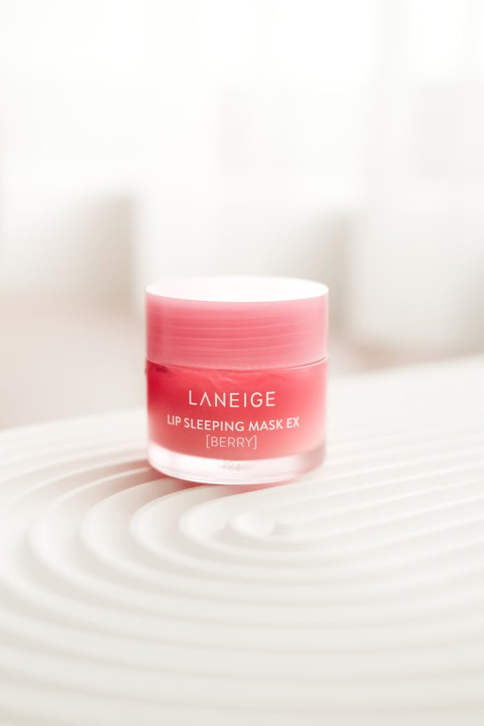 Close-up of Laneige Lip Sleeping Mask EX in berry flavor on textured surface. Product photography. Koreansk Hudvård Sverige - The Beauty Army